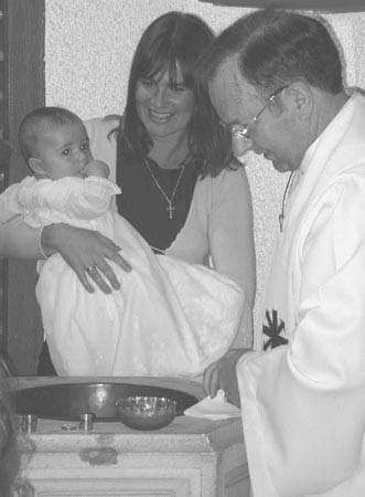 A baptism: baby, mother and Fr Michael